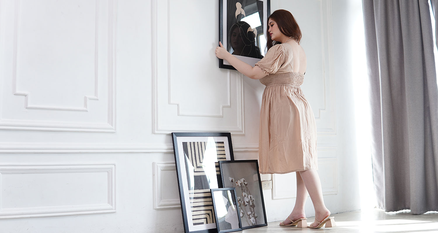 Artdesign poster prints in black frame in white interior wall.