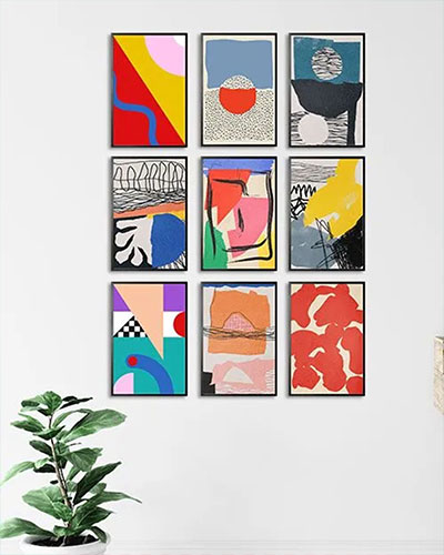 Different kinds of poster prints together as a bundle on a plain wall as home decoration.