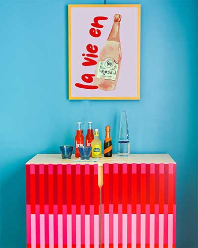 A poster print with a French word "La vie en" displayed in a blue wall.